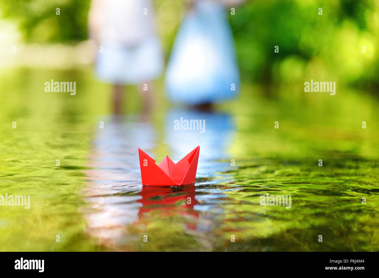 Red paper boat floating on a river Stock Photo