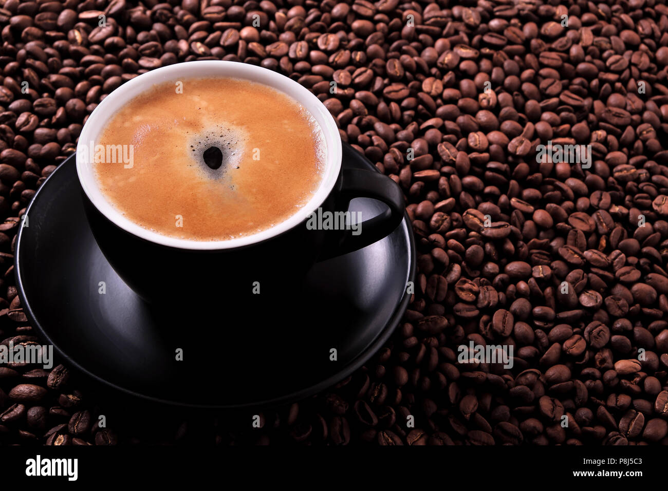 Black coffee cup with roasted beans background Stock Photo