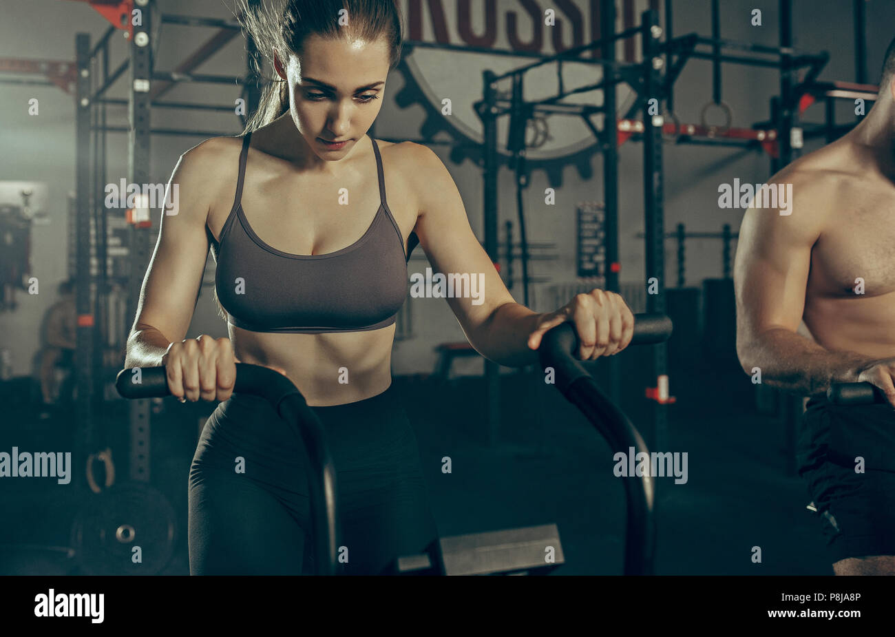 Man and woman during exercises in the fitness gym Stock Photo - Alamy