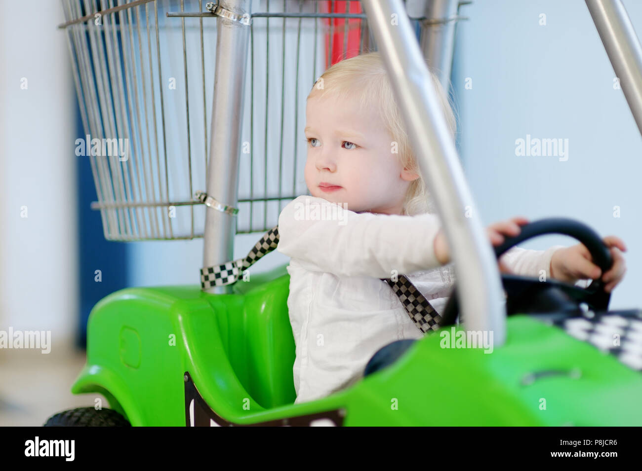 Adorable little girl sitting in shopping cart Stock Photo - Alamy