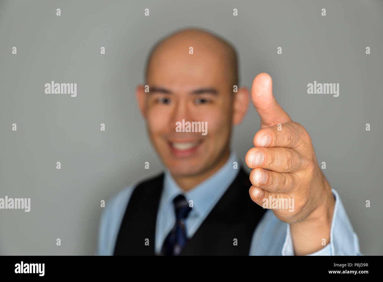 Blurred Businessman Offering Clear Handshake and Smile - Concept for Success, Teamwork and Welcome Stock Photo
