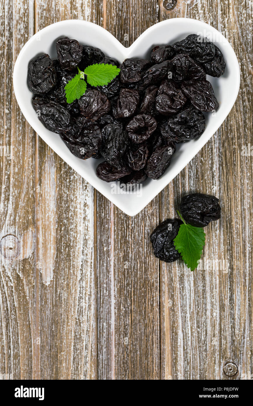 Dried Plums Pitted Prunes in Heart Shaped Bowl Background Stock Photo