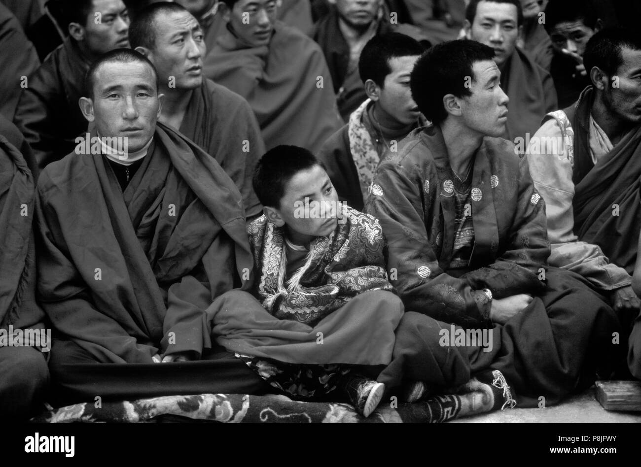 Nyingma monks watch the Buddhist Cham Dances, Katok Dorjeden Monastery - Kham, (E. Tibet), Sichuan Province, China Stock Photo