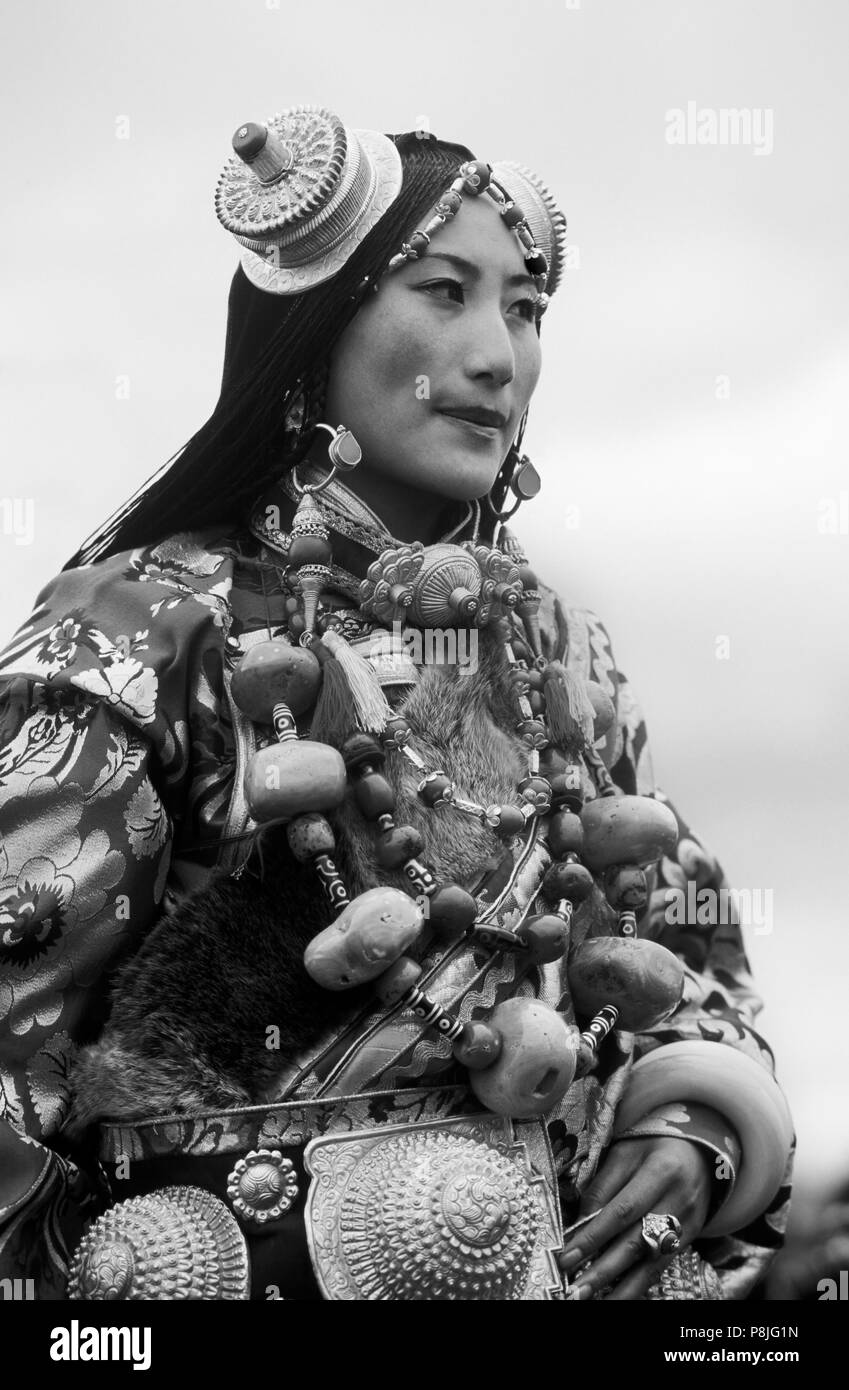 Female Khampa wears gold hair pieces & gau boxes, zee stones & coral at the Litang Horse Festival - Sichuan Province, China Stock Photo