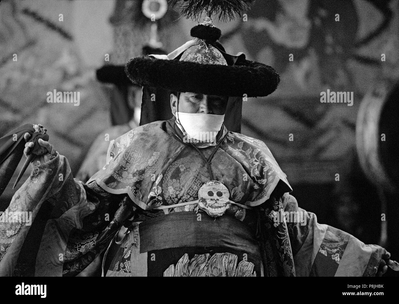 TANTRIC DANCER in silk costume, with scarf to prevent inhaling living beings, TIKSE Monastery Masked Dances - LADAKH, INDIA Stock Photo