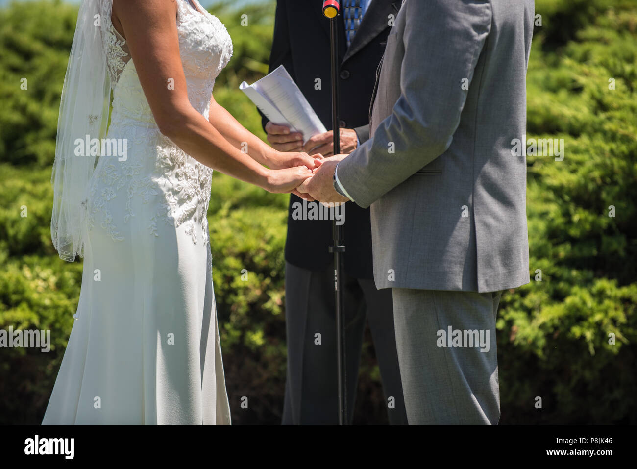 Man and woman at alter with officiate to say their vows in the wedding ceremony. Stock Photo