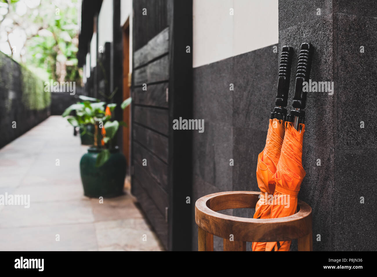 Two orange umbrellas in wooden basket outside room hotel. Resort service Stock Photo
