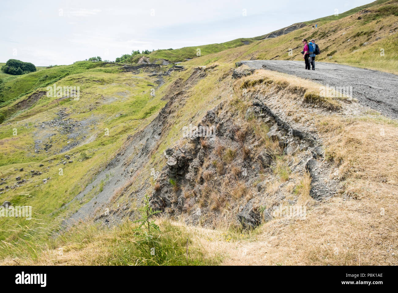 People looking at landslide road damage. The A625 below Mam Tor was