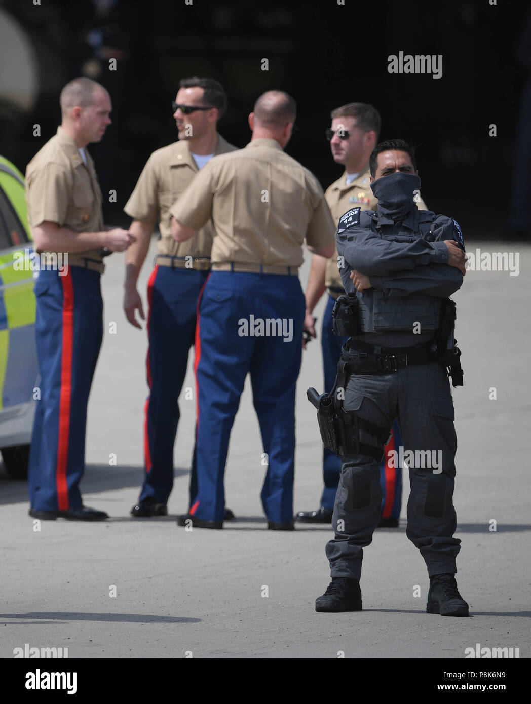 US military personnel and Metropolitan Police Counter Terrorist Specialist Firearms Officer on the tarmac ahead of the the arrival of US President Trump and Melania Trump at Stansted Airport, London for their first official visit to the UK. Stock Photo