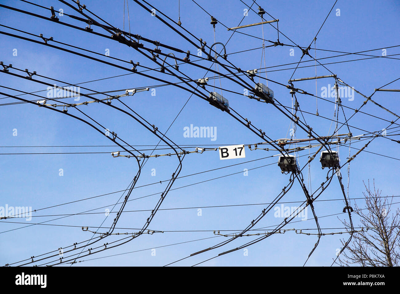 Black tram wires over blue sky . Urban transportation system Stock Photo