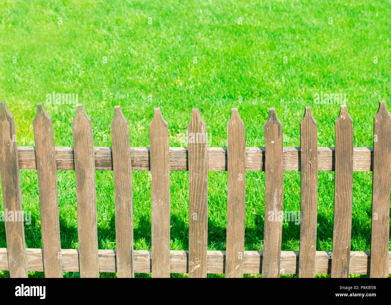 wooden fence on a background of green grass Stock Photo - Alamy