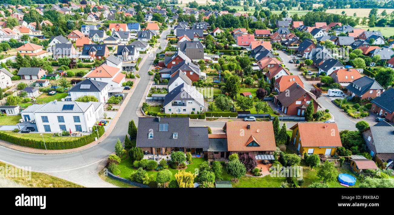 Typical German new housing development in the flat countryside of northern Germany between a forest and fields and meadows, made with drone Stock Photo
