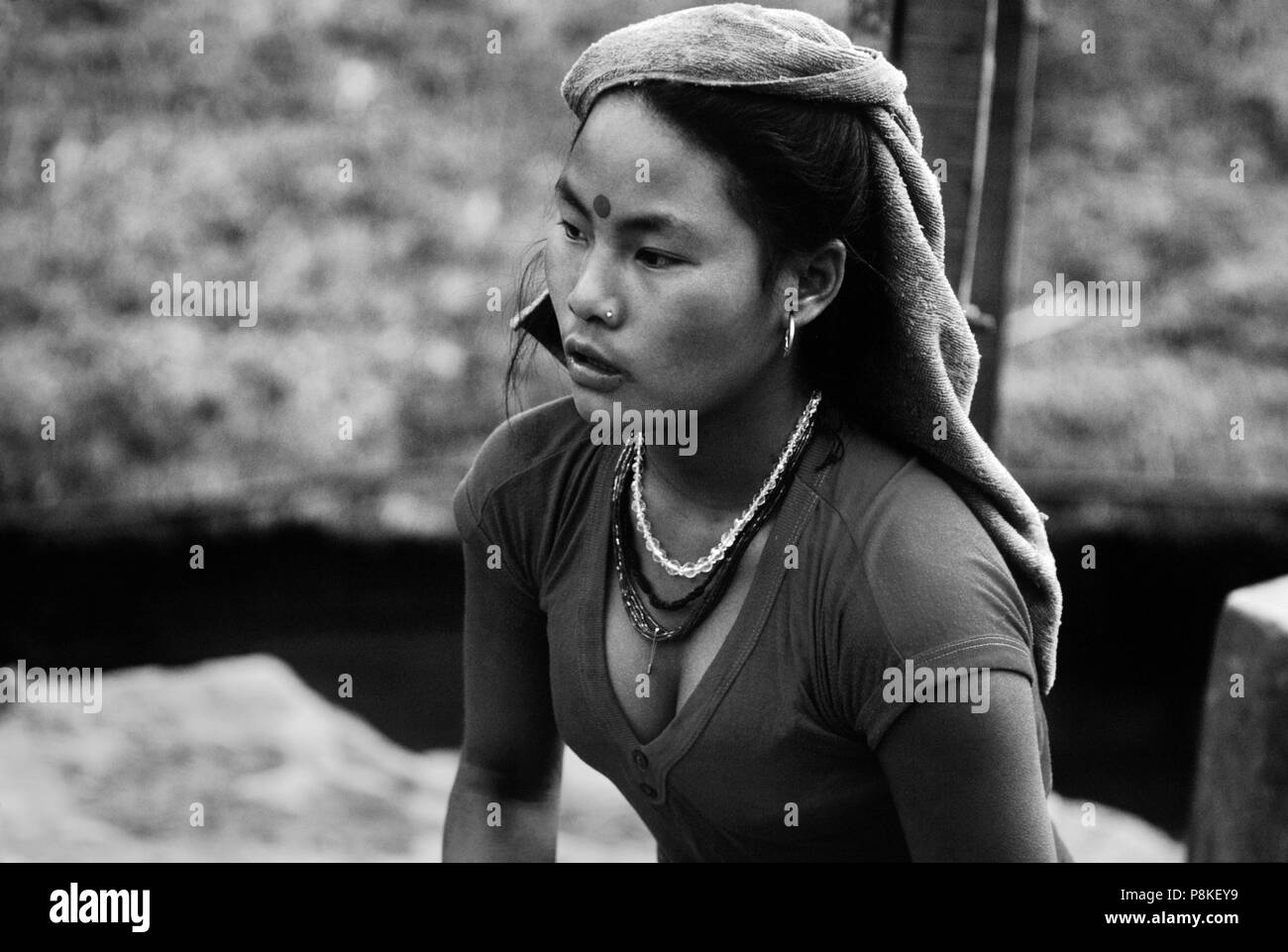 BEAUTIFUL YOUNG GURUNG WOMAN with nose ring and golden earring - ANNAPURNA REGION, CENTRAL NEPAL Stock Photo