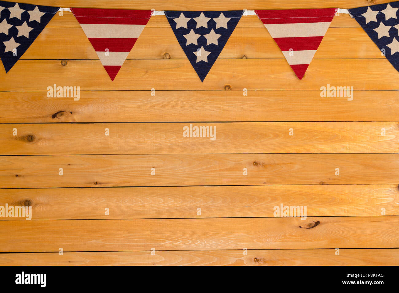 Patriotic Stars and Stripes American bunting on a garland or string as a top border on natural wood with copy space for Independence Day Stock Photo