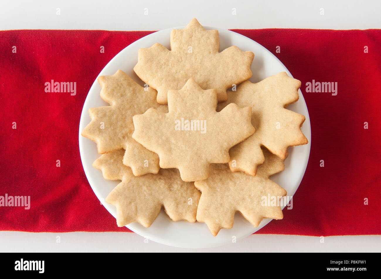 Round white plate filled with maple leaf shaped sugar cookies Stock Photo