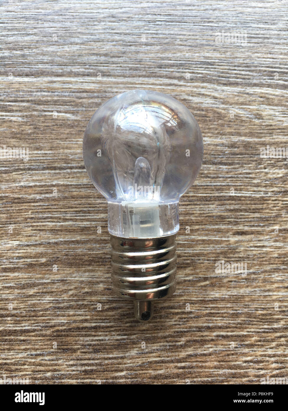 Small electric bulb on a wood floor Stock Photo