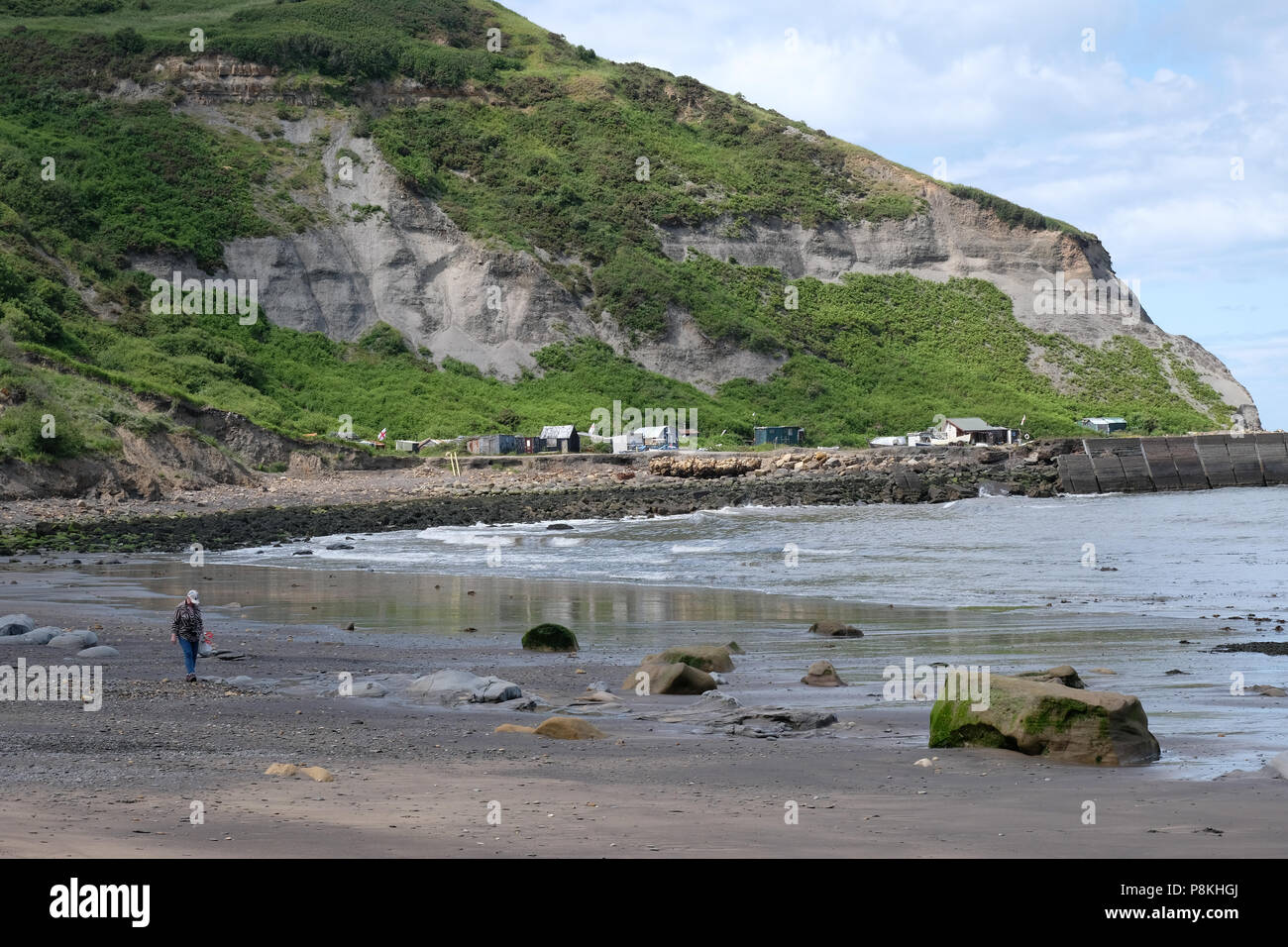 The treacherous way down to the cabins and huts at the old harbour of Port Mulgrave on the Yorkshire Heritage Coast, England,UK, English flag flying. Stock Photo