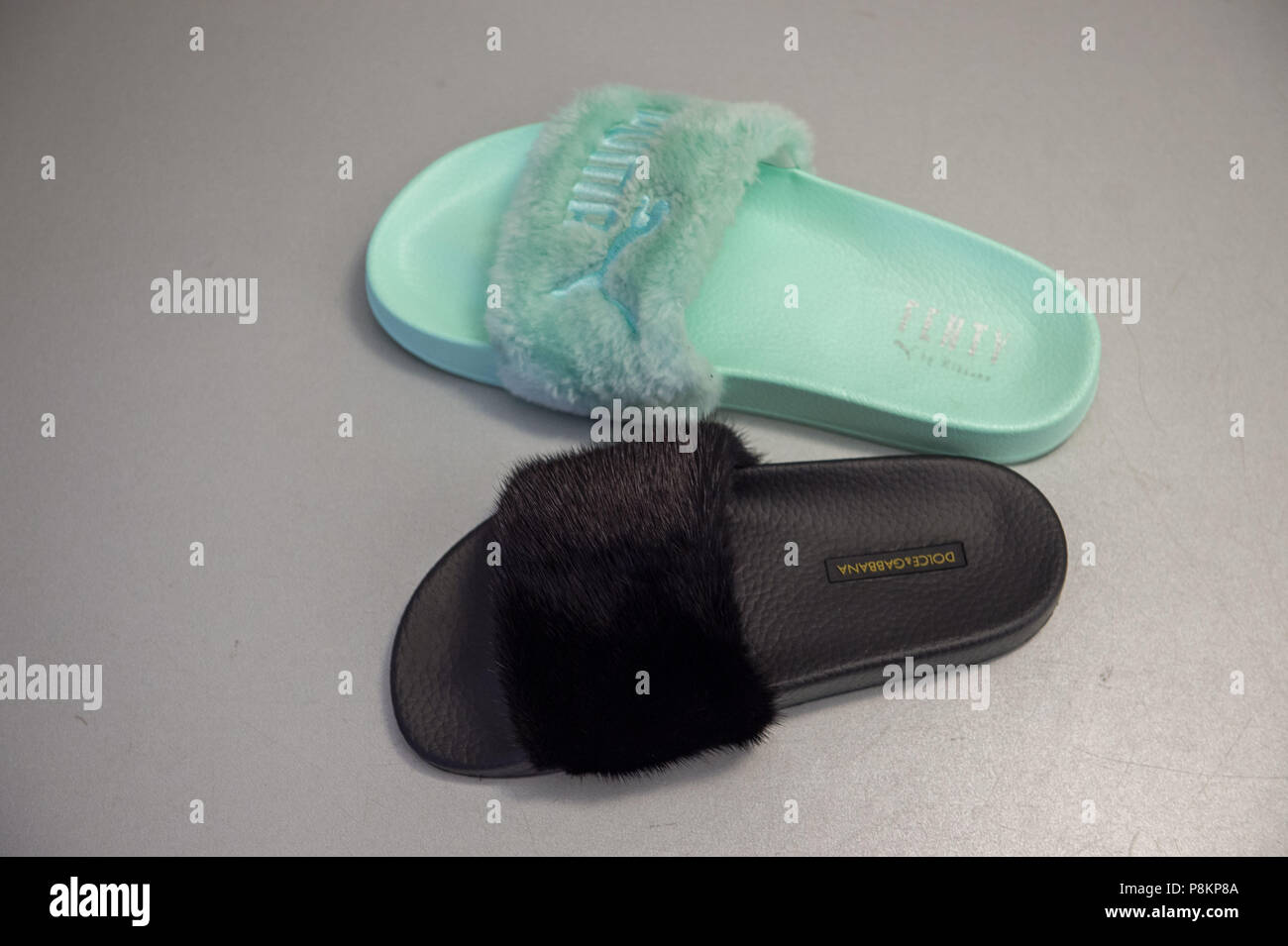 Munich, Germany. 12th July, 2018. Furry bathing sandals of the brands Puma  (Up) and Dolce & Gabbana lie on a table in the courtroom of the Higher  Regional Court. The Franconian company