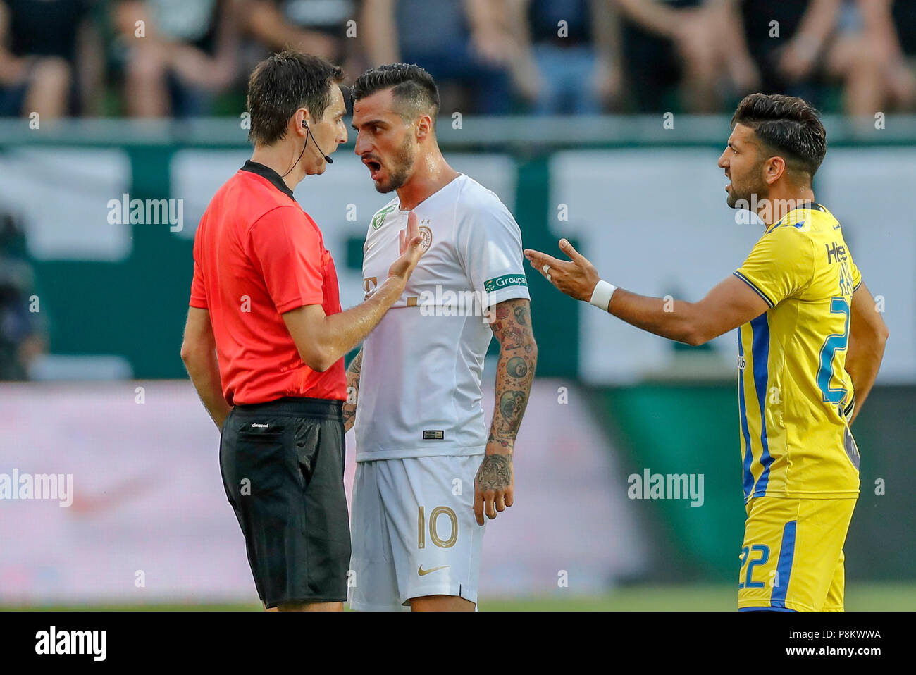 Budapest, Hungary. 12th July, 2018. Davide Lanzafame of Ferencvarosi TC (l2) argues with referee Ricardo De Burgos (l) next to Avi Rikan of Maccabi Tel Aviv FC (r) during the UEFA Europa League First Qualifying Round 1st Leg match between Ferencvarosi TC and Maccabi Tel Aviv FC at Groupama Arena on July 12, 2018 in Budapest, Hungary. Credit: Laszlo Szirtesi/Alamy Live News Stock Photo