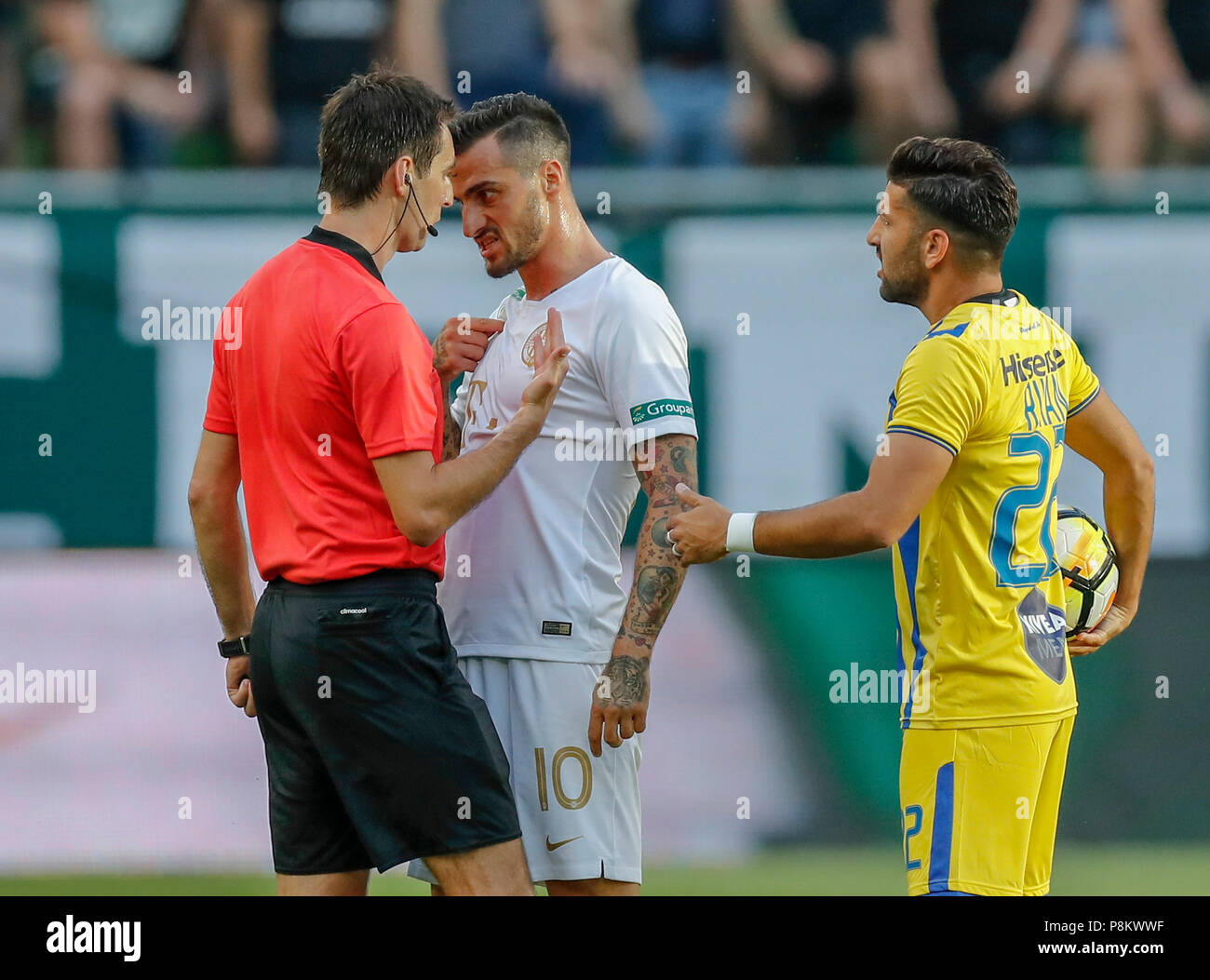 Budapest, Hungary. 12th July, 2018. Davide Lanzafame of Ferencvarosi TC (l2) argues with referee Ricardo De Burgos (l) next to Avi Rikan of Maccabi Tel Aviv FC (r) during the UEFA Europa League First Qualifying Round 1st Leg match between Ferencvarosi TC and Maccabi Tel Aviv FC at Groupama Arena on July 12, 2018 in Budapest, Hungary. Credit: Laszlo Szirtesi/Alamy Live News Stock Photo