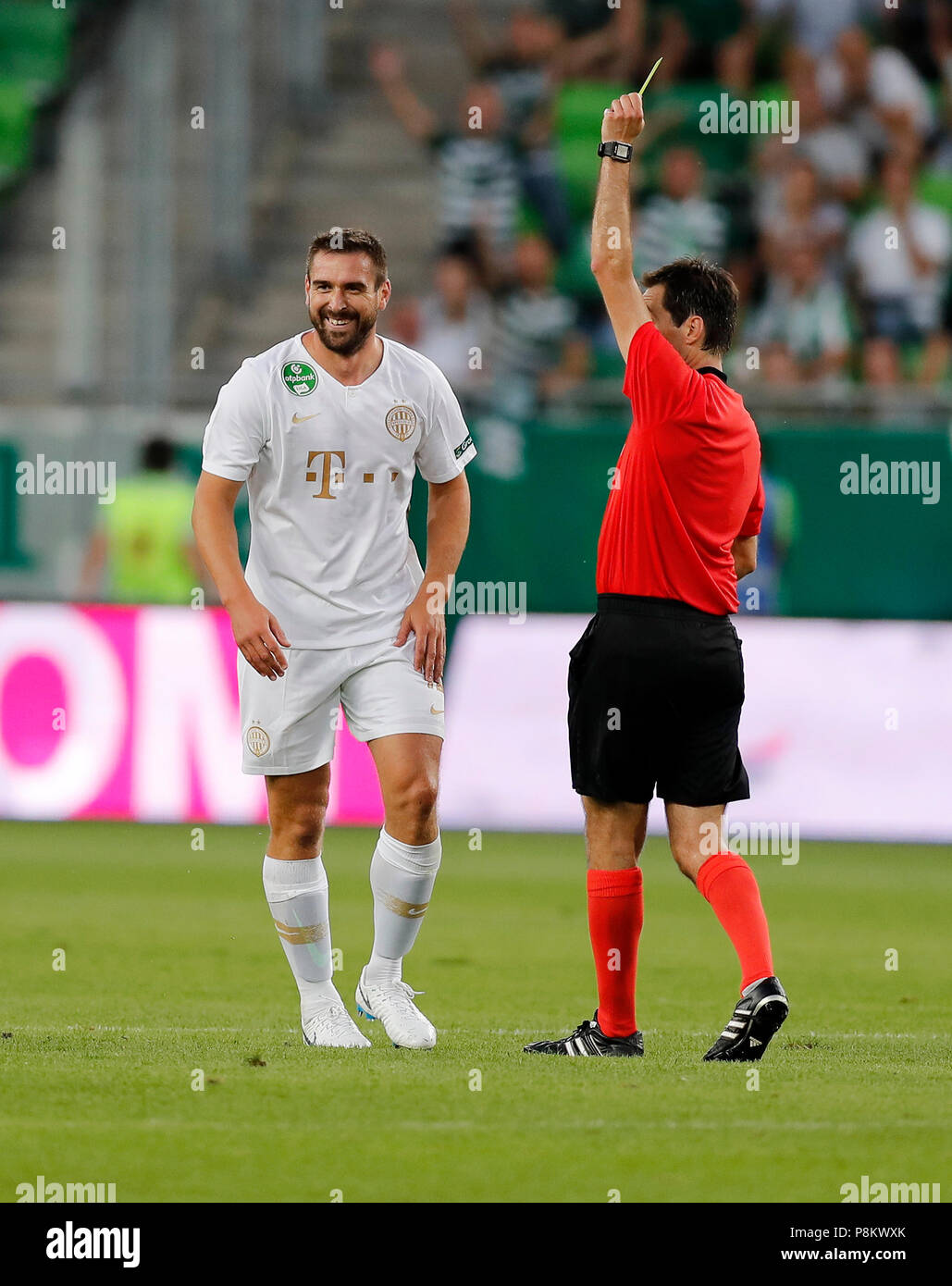 Budapest, Hungary. 12th July, 2018. (r-l) Referee Ricardo De Burgos shows the yellow card for Daniel Bode of Ferencvarosi TC during the UEFA Europa League First Qualifying Round 1st Leg match between Ferencvarosi TC and Maccabi Tel Aviv FC at Groupama Arena on July 12, 2018 in Budapest, Hungary. Credit: Laszlo Szirtesi/Alamy Live News Stock Photo