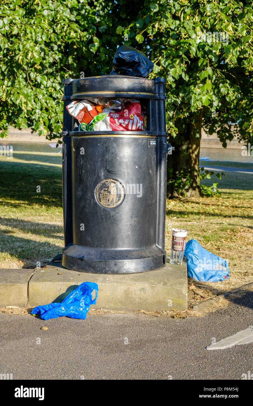 Full litter bin overflowing with rubbish on top and around it on the ground, Nottinghamshire, England, UK Stock Photo