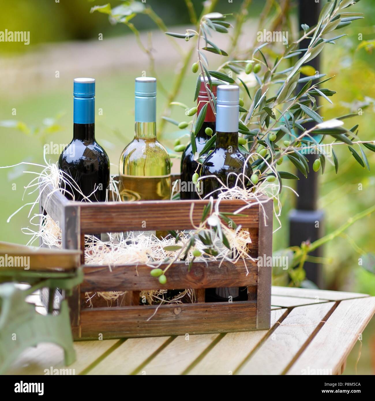 Wine bottle in a vintage wooden crate decorated with olive branches Stock Photo