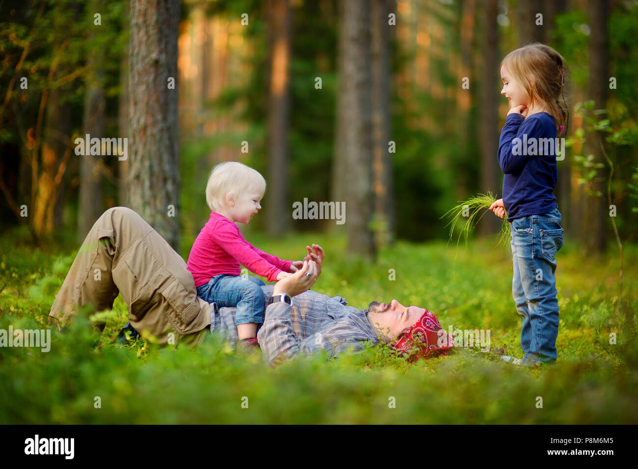 Young father and his two little daughters in forest Stock Photo - Alamy
