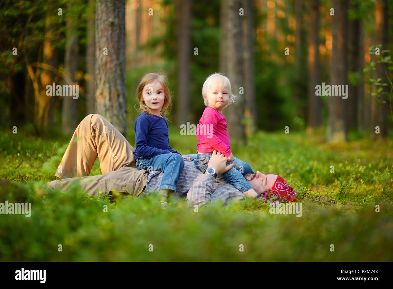 Young father and his two little daughters in forest Stock Photo - Alamy