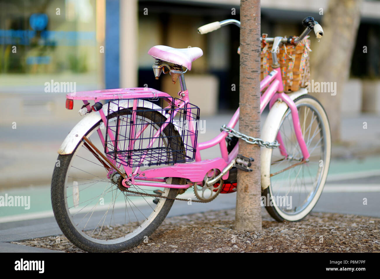 Fancy pink bike parked by a tree in New York, USA Stock Photo
