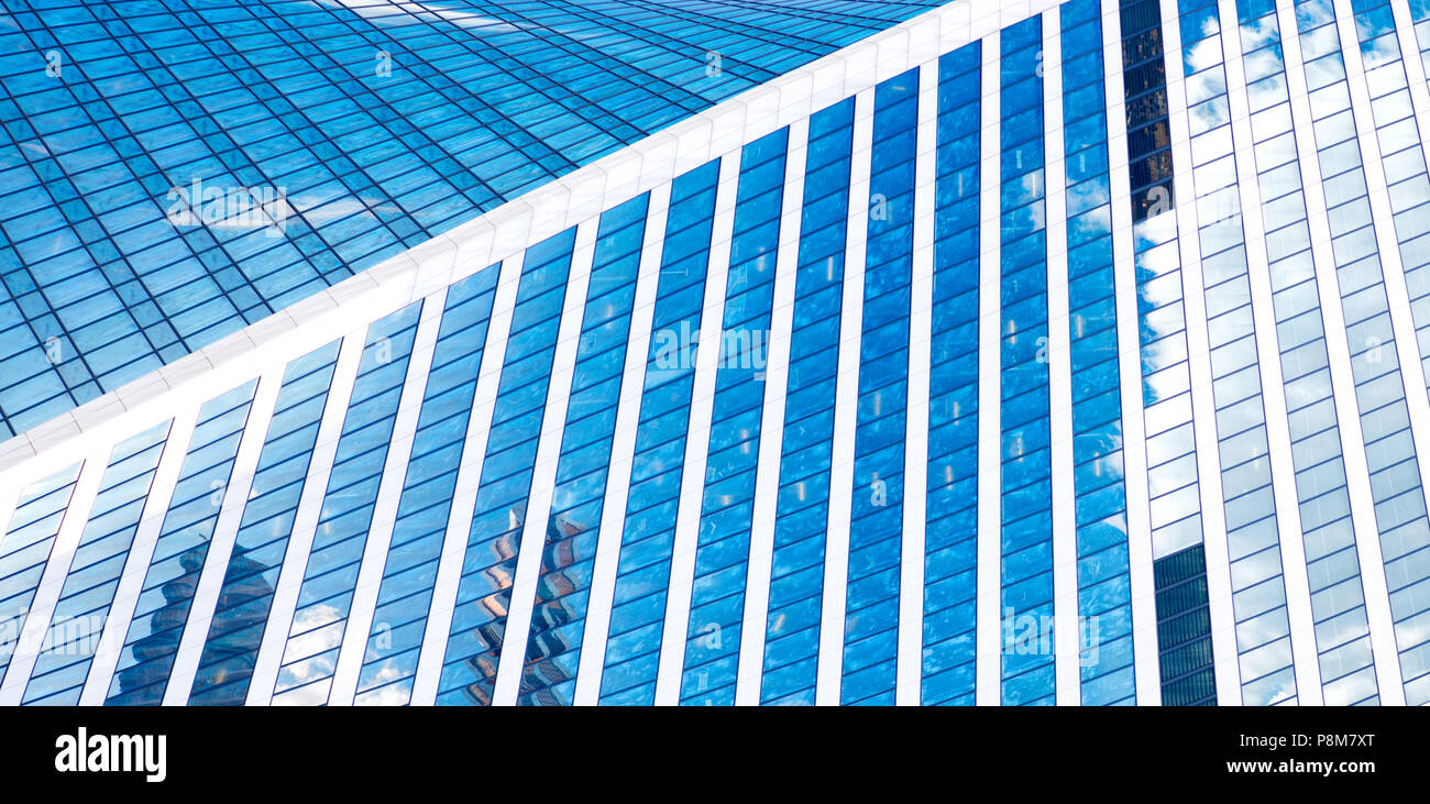 Abstract skyscrapers with reflection in windows blue sky, white clouds ...