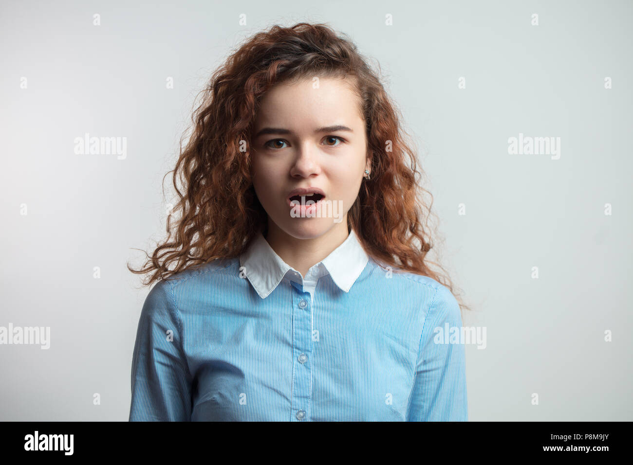 close up portrait of pleasant redhaire girl with opened mouth looking at the camera. indignation concept Stock Photo