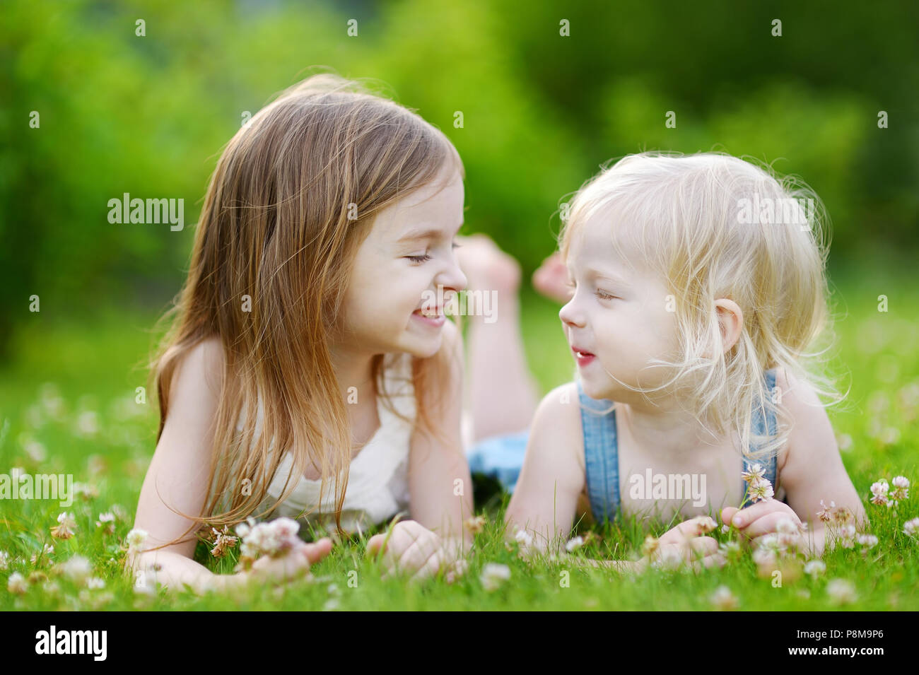 Little girl laying in the grass hi-res stock photography and ...