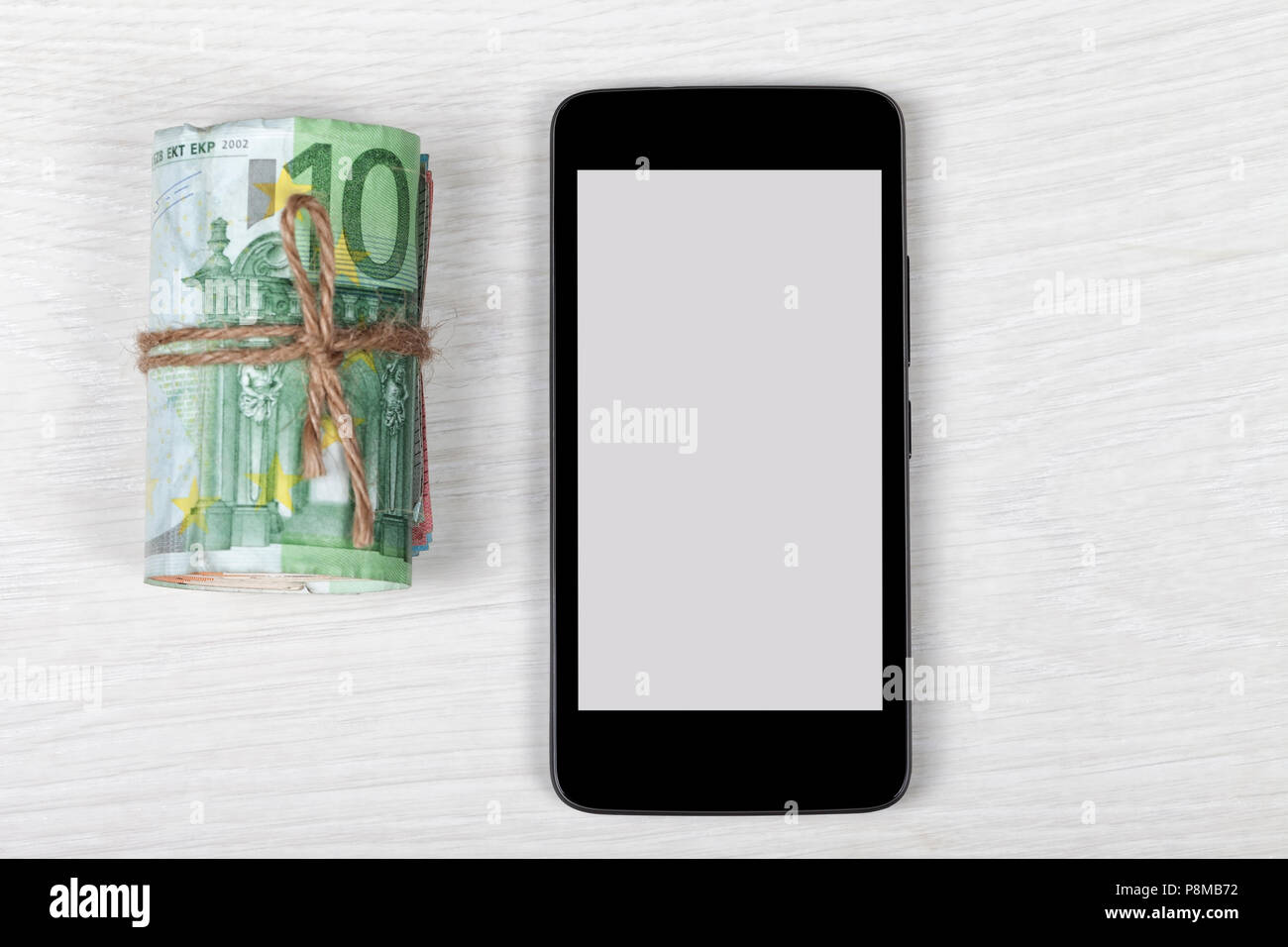 A black smartphone template with the blank screen next to a wad of euro bills. Stock Photo