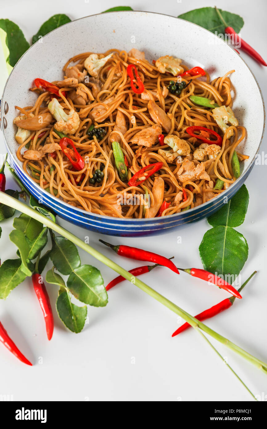 traditional spicy asian cuisine food: wok stir fry spaghetti with fried  chicken and thai spices and herbs Stock Photo - Alamy