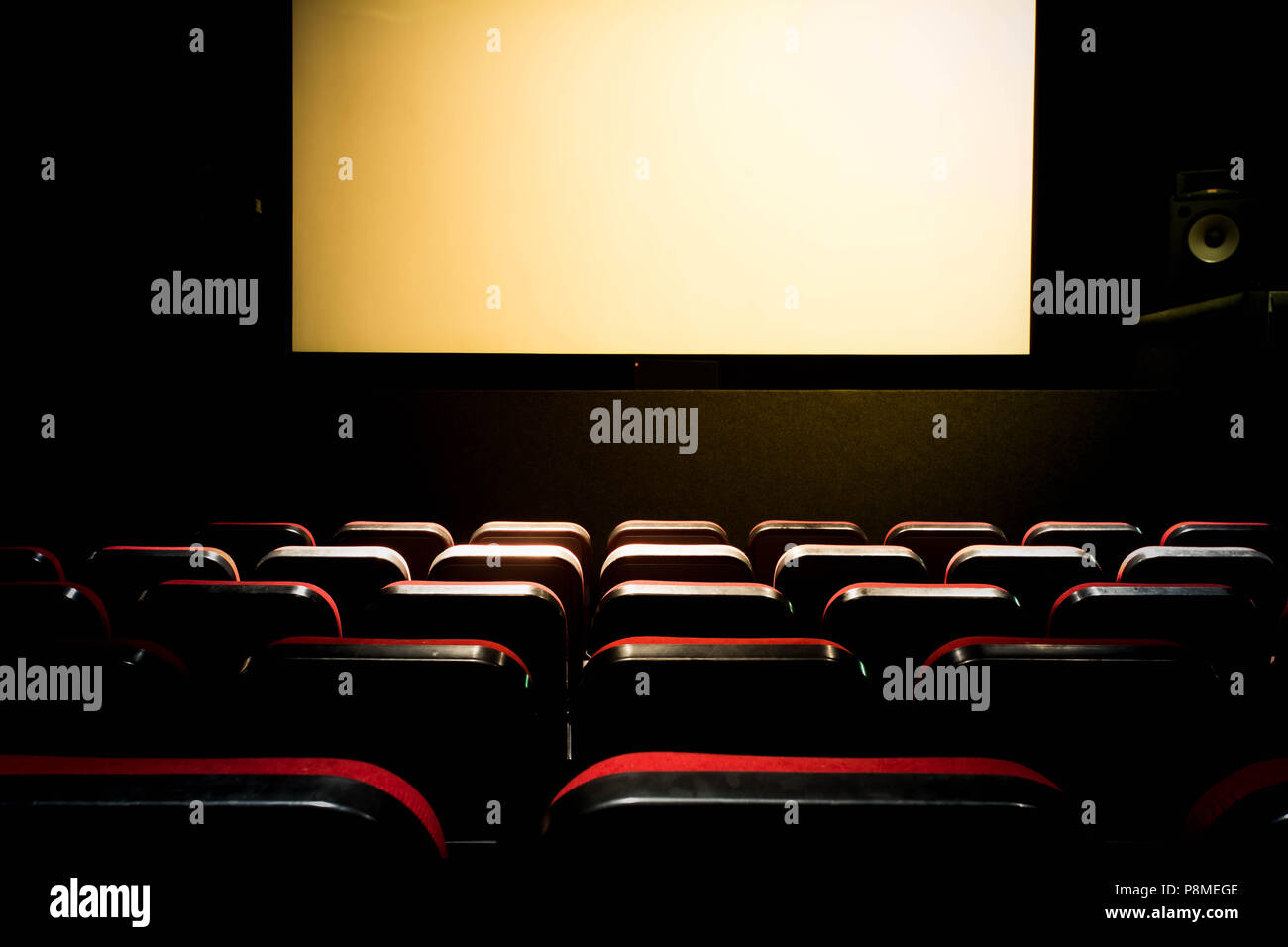 Movie Cinema hall with a white empty screen premiere with red seats Stock Photo