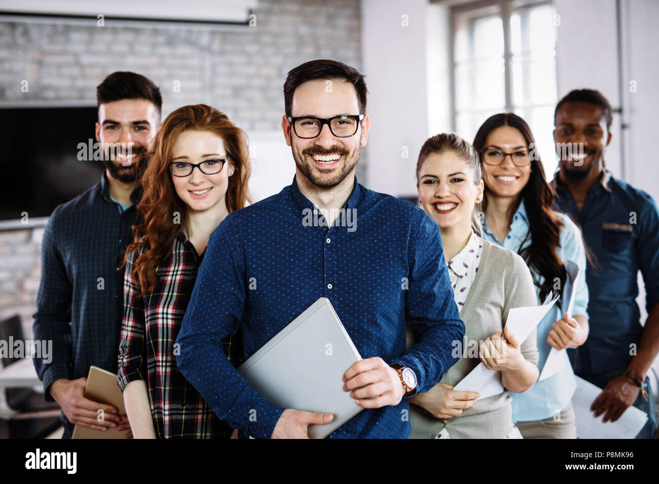 Portrait of successful business team posing in office Stock Photo - Alamy