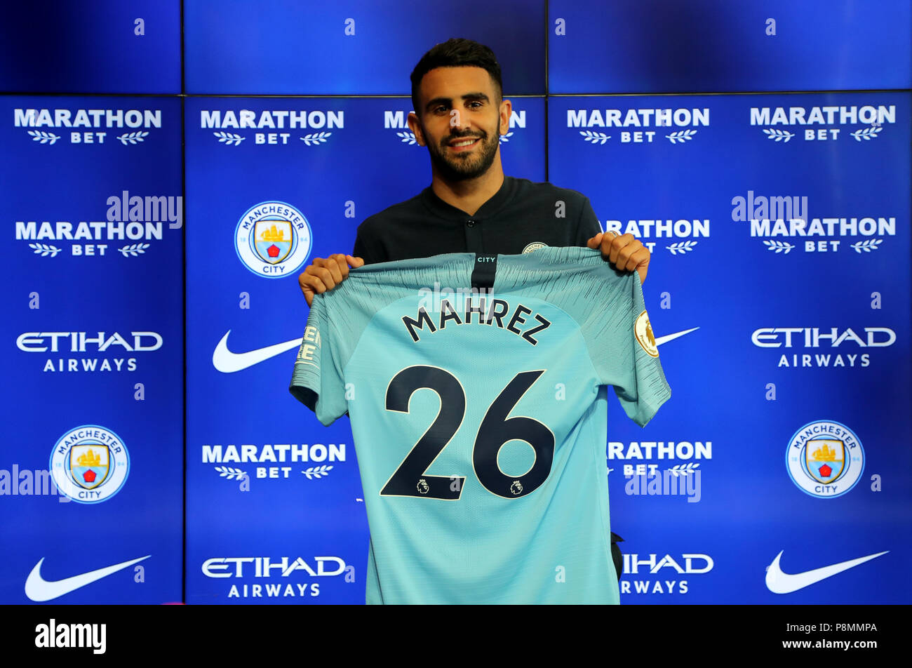 New Manchester City signing Riyad Mahrez holds up his shirt during the  press conference at the City Football Academy, Manchester Stock Photo -  Alamy