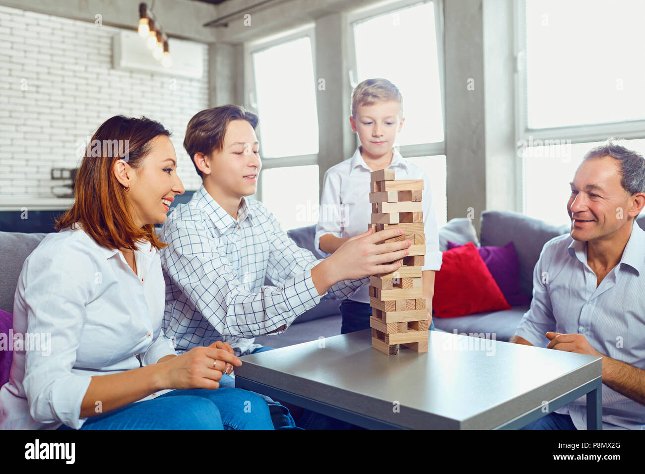 The family plays board games inside the room. Stock Photo