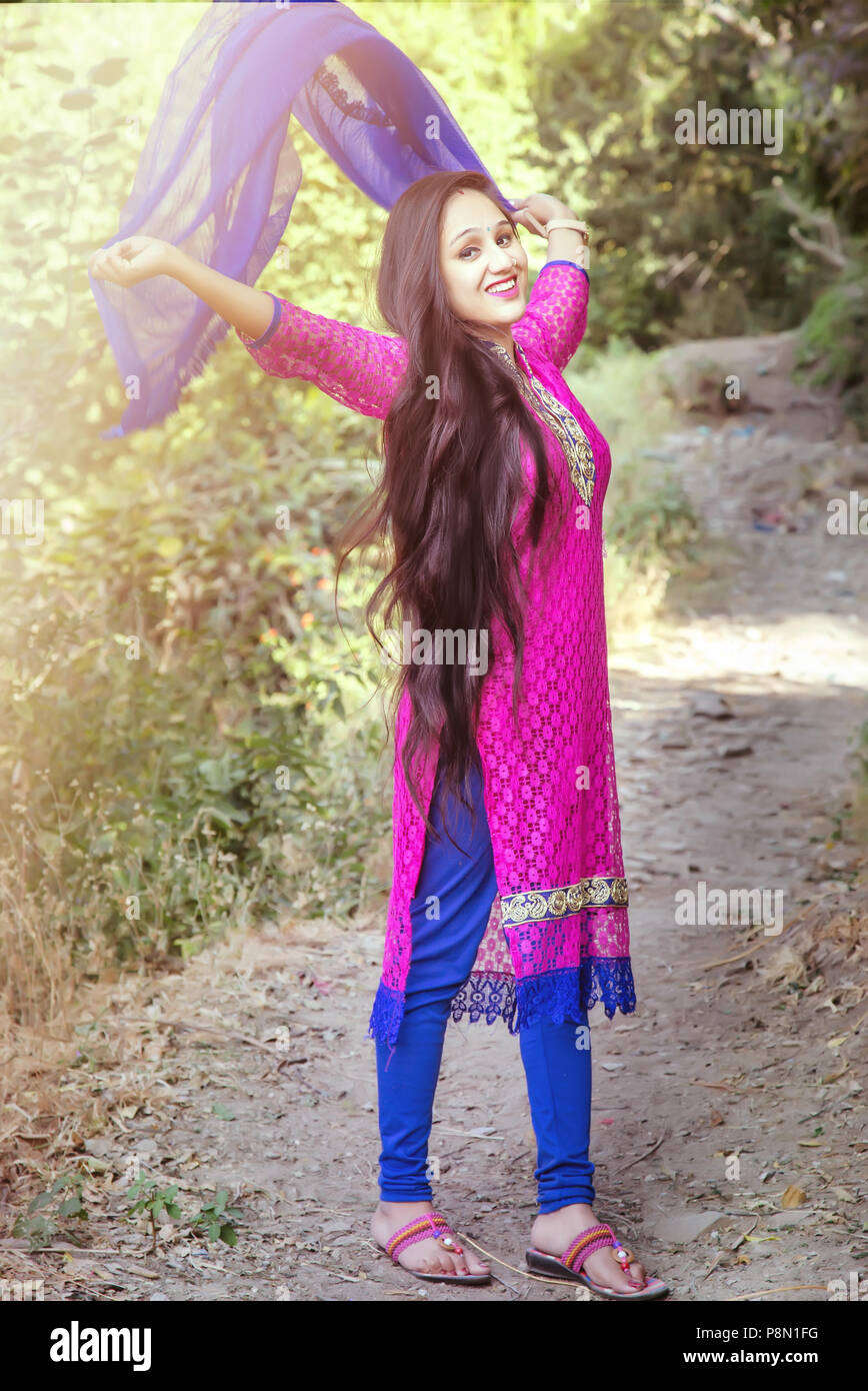 Woman with long hair and beautiful eyes on a green background wearing  Indian suit and dupatta. Lady portrays dancing, jumping, fun, happiness,  smile Stock Photo - Alamy