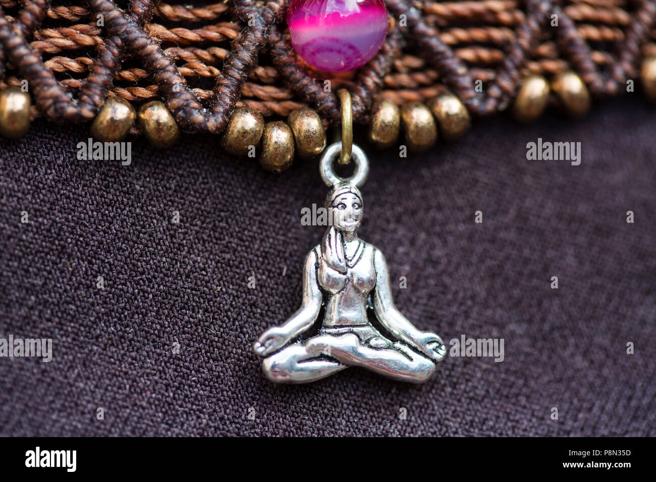 Zinc Alloy pendant jewellery in the shape of meditating yoga girl Stock Photo