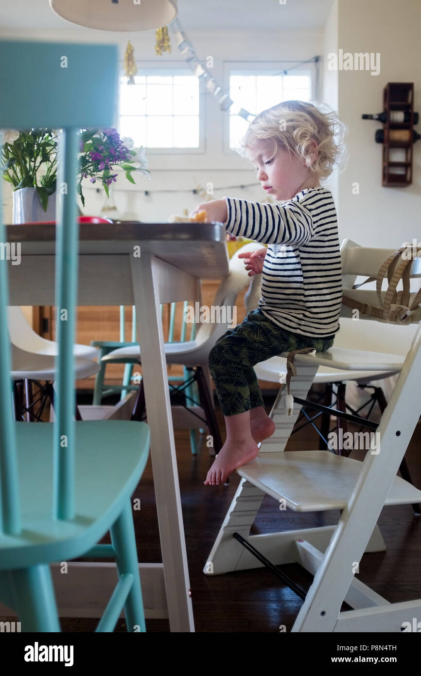 Boy at table on step ladder Stock Photo