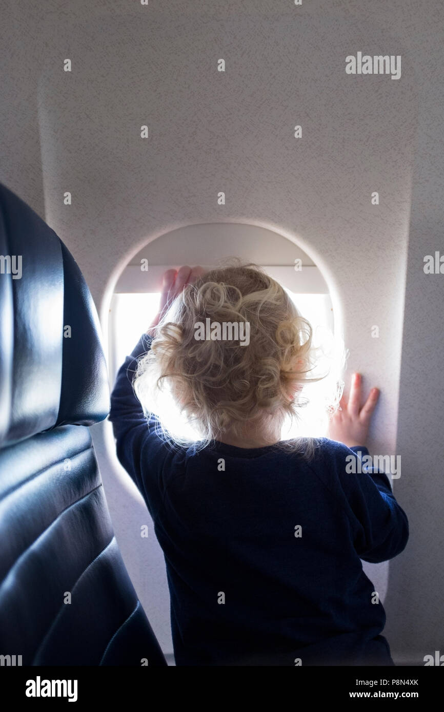 Boy by window on airplane Stock Photo