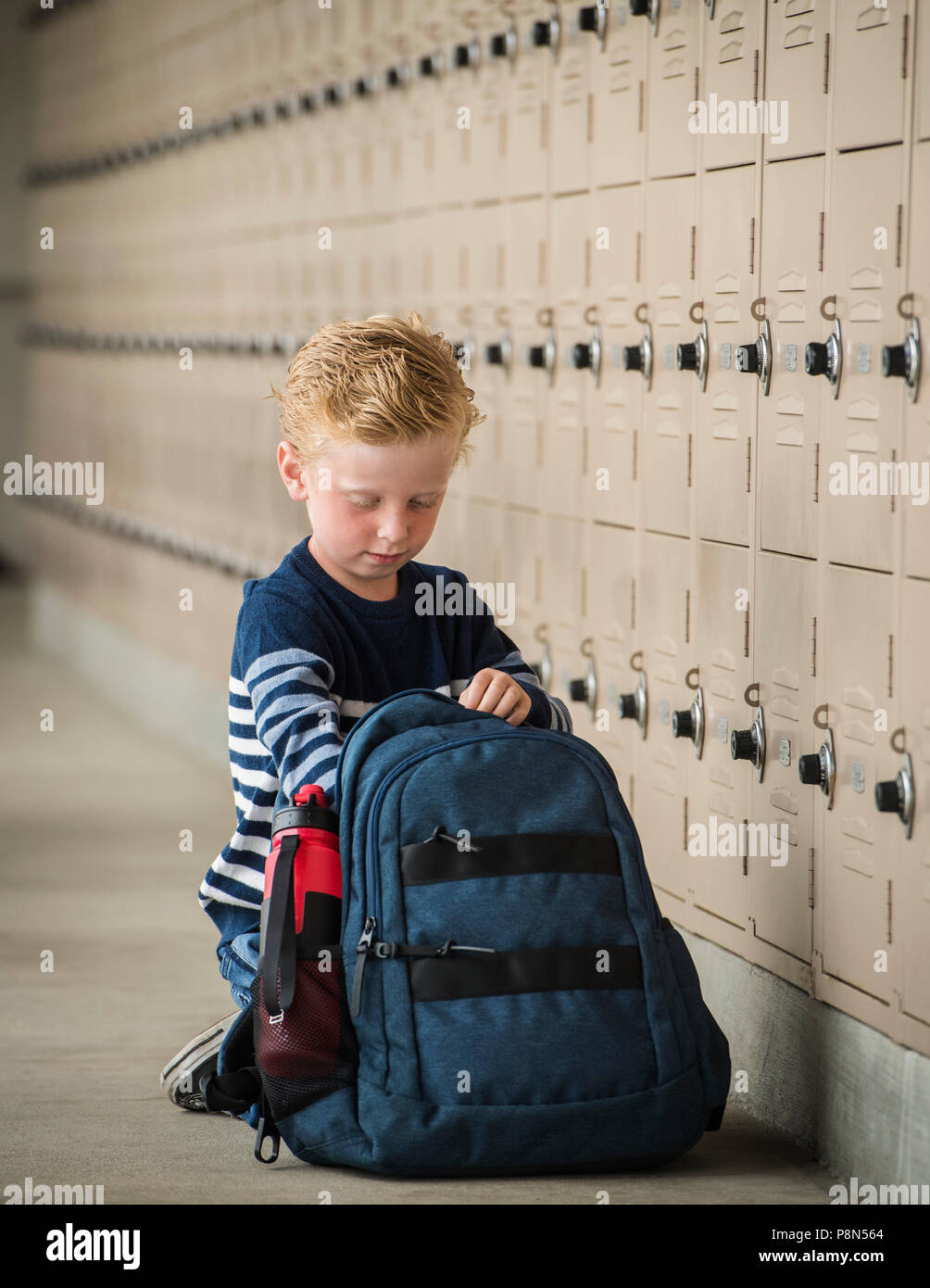 Boy with backpack by school lockers Stock Photo - Alamy