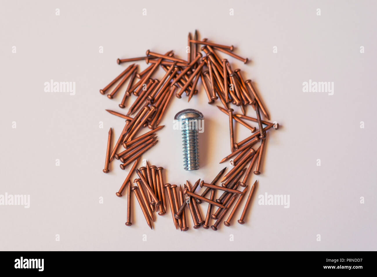 Close up of a group of bronze nails and a single metal screw. Stock Photo