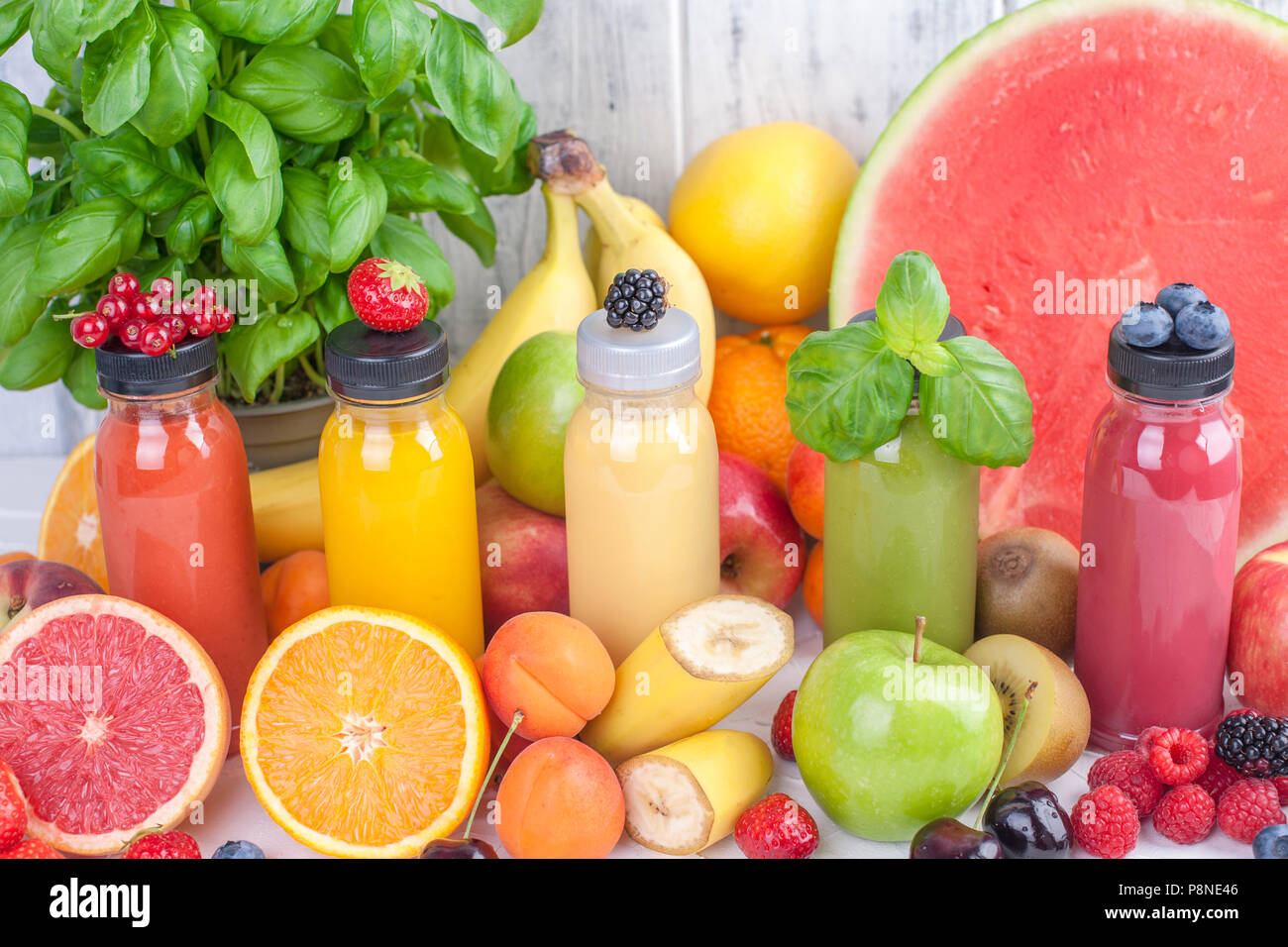 Many different fruits and berries, juice in bottles. Vitamins and healthy food. Summer Products. Copy space Stock Photo
