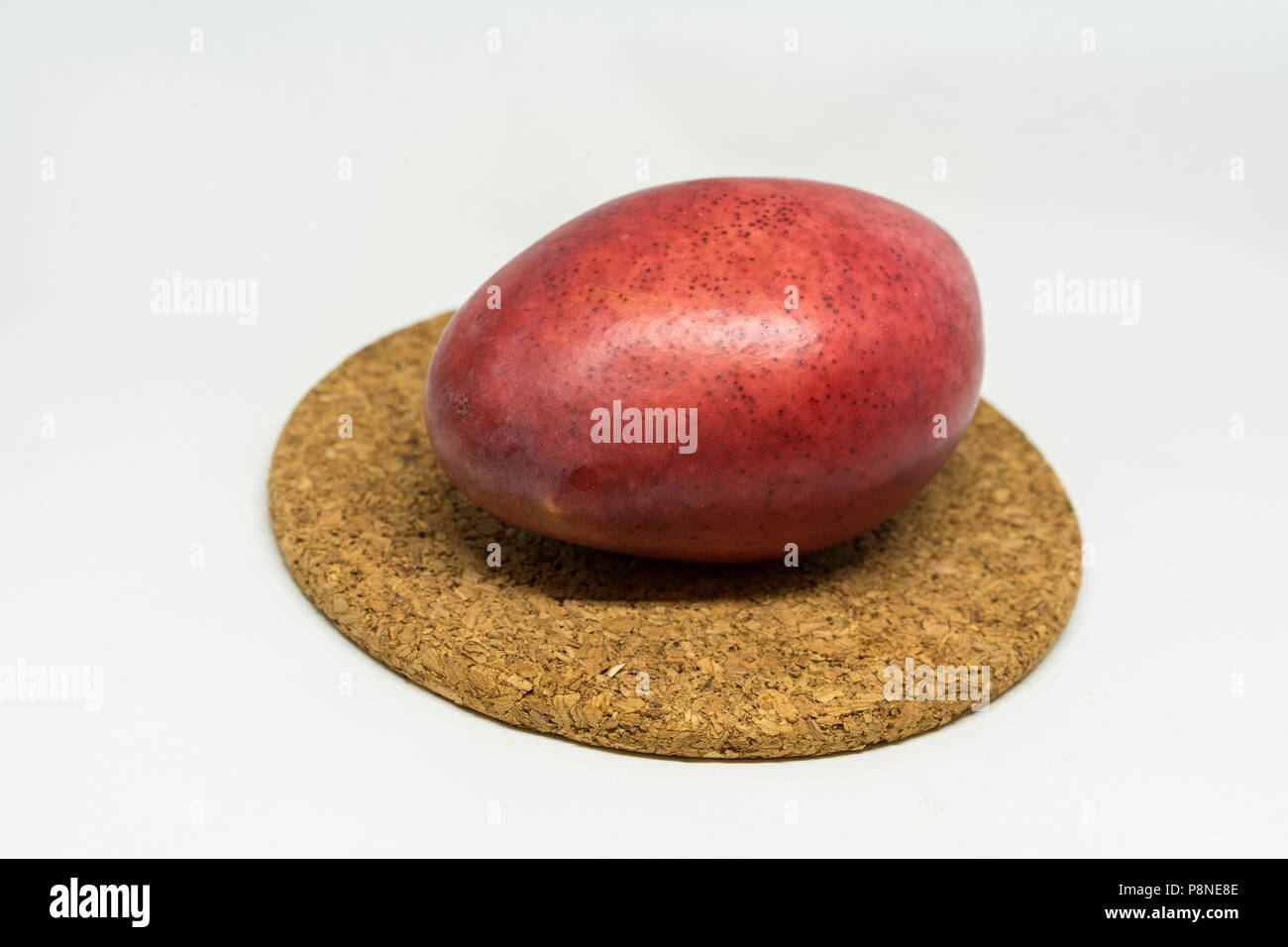 red mango fruit on cork isolated on white background Stock Photo