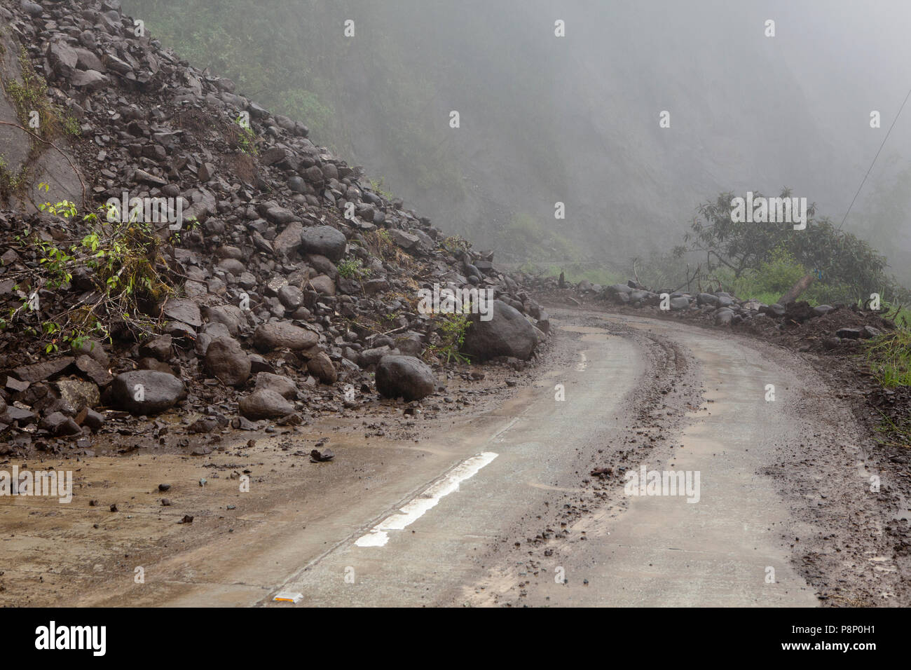 Landslides caused by excessive rainfall nearly block the road Stock Photo