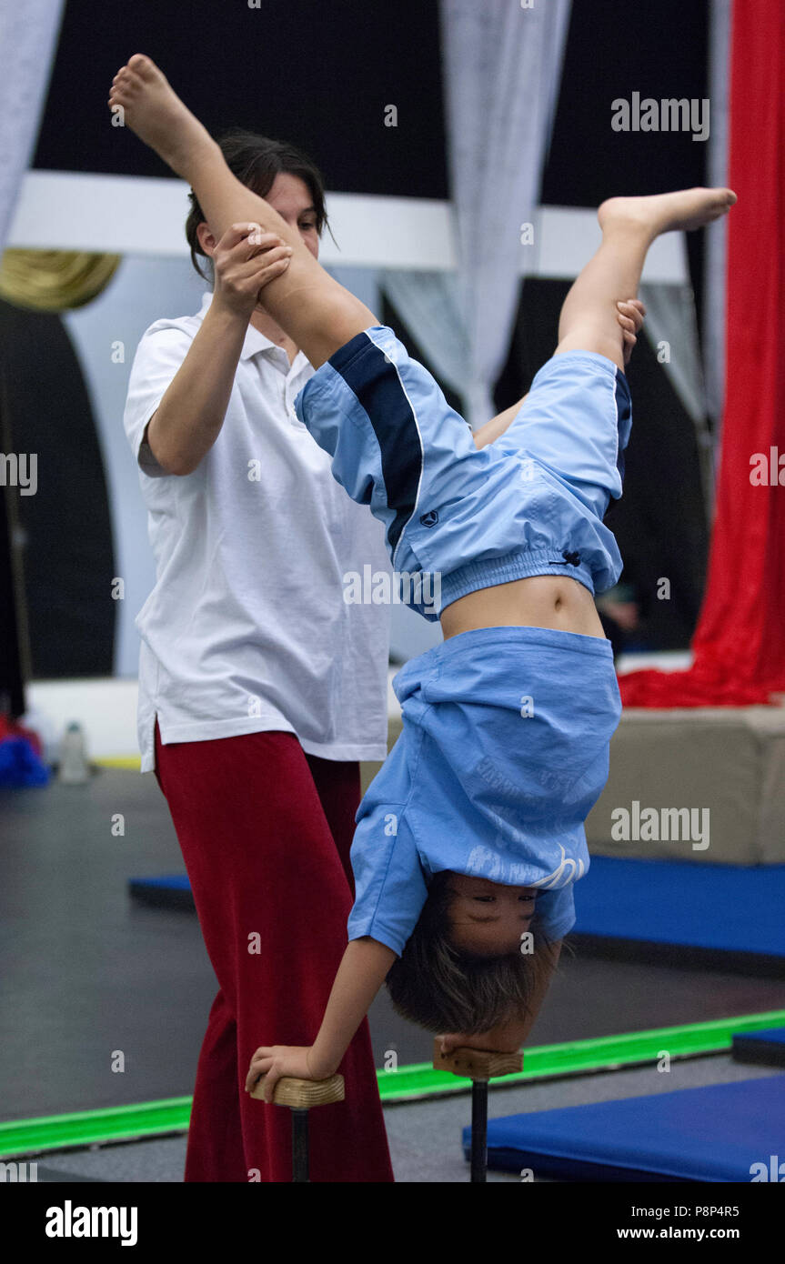 Practised Acrobatics A young boy practices standing on his hands in acrobat school while ...