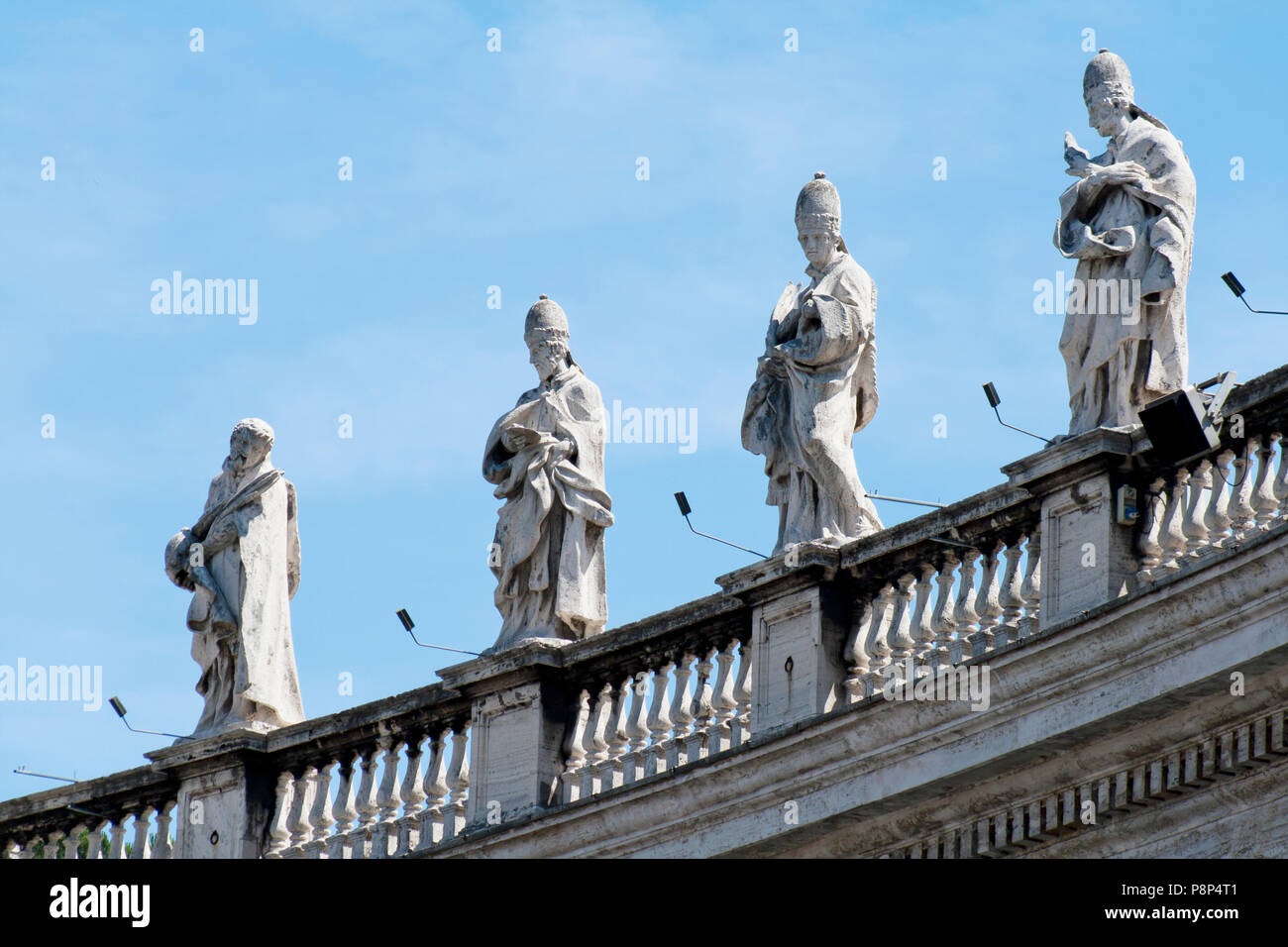 Bernini's colonnade in the Vatican, statues against blue sky Stock Photo